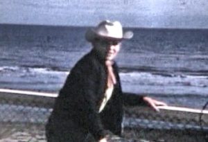 Boy in a cowboy hat in front of the ocean